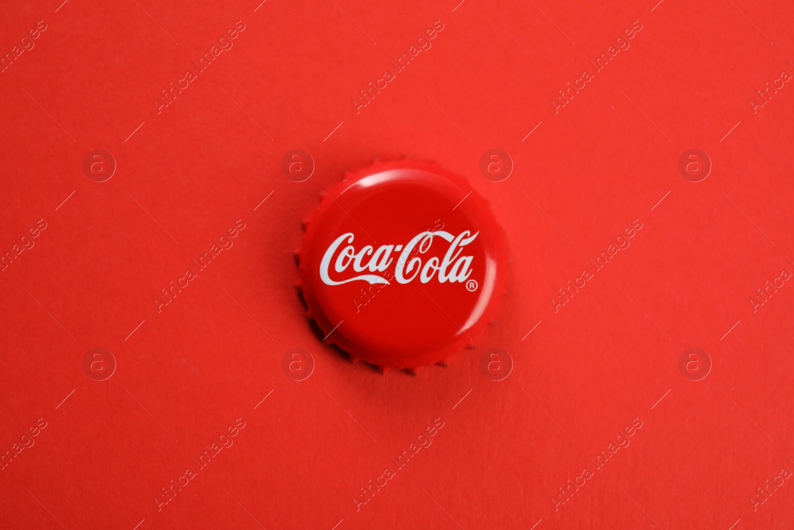 Photo of MYKOLAIV, UKRAINE - NOVEMBER 15, 2018: Coca Cola lid on color background, top view