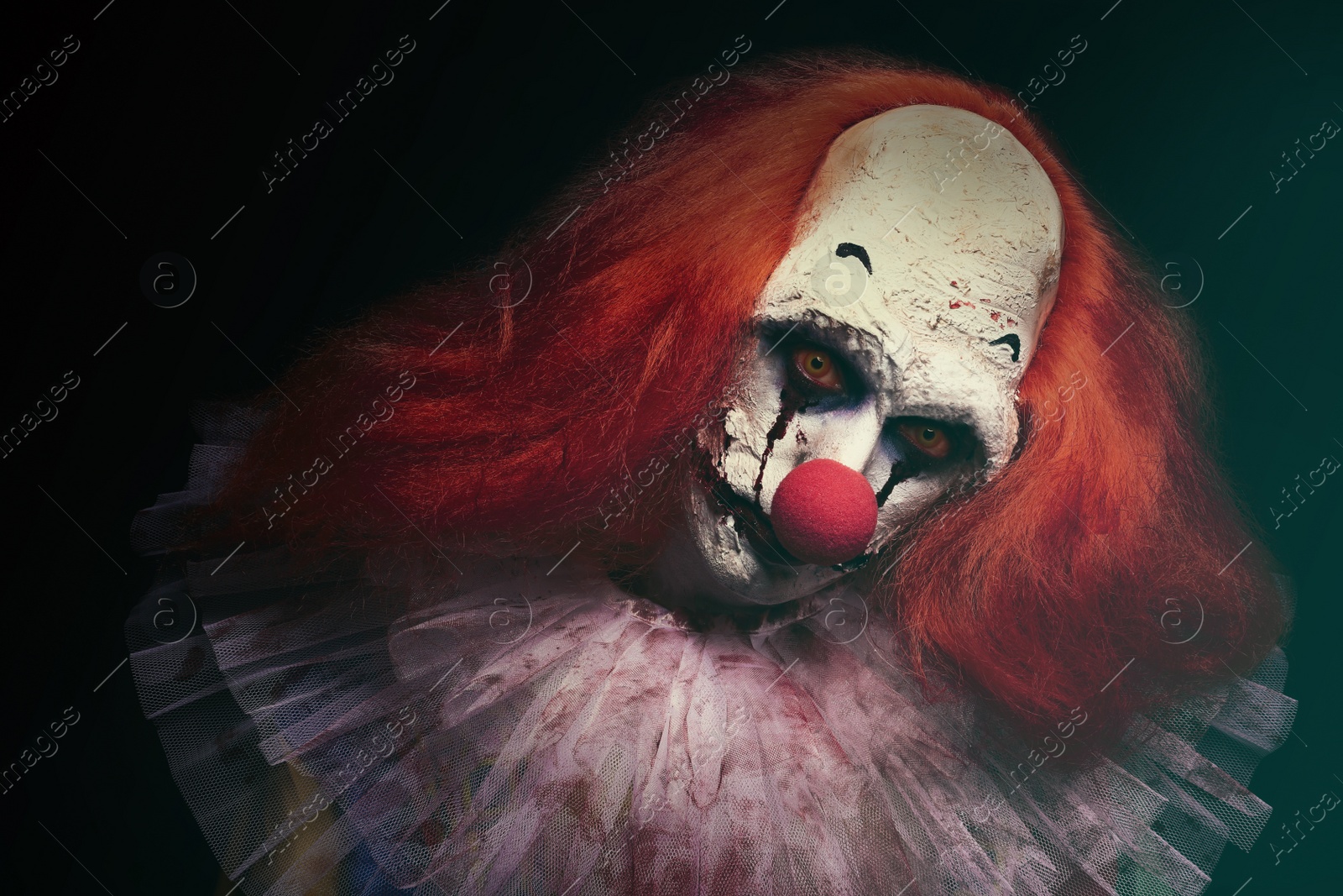 Photo of Terrifying clown on black background. Halloween party costume