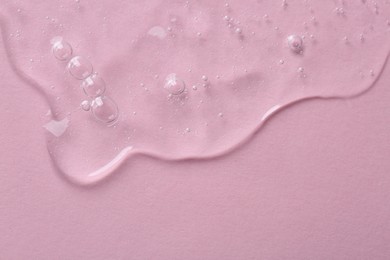 Photo of Cosmetic serum on pink background, top view. Space for text