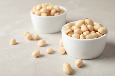 Photo of Shelled peanuts in bowl on table. Space for text