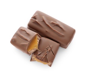 Photo of Pieces of chocolate bars with caramel on white background, top view