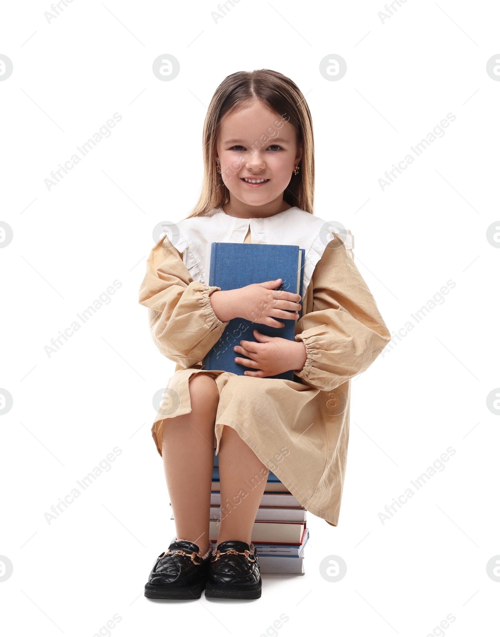 Photo of Cute little girl sitting on stack of books against white background