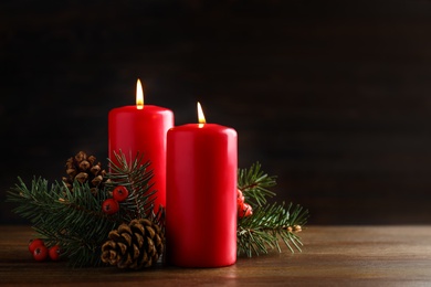 Photo of Beautiful composition with candles and Christmas decor on wooden table