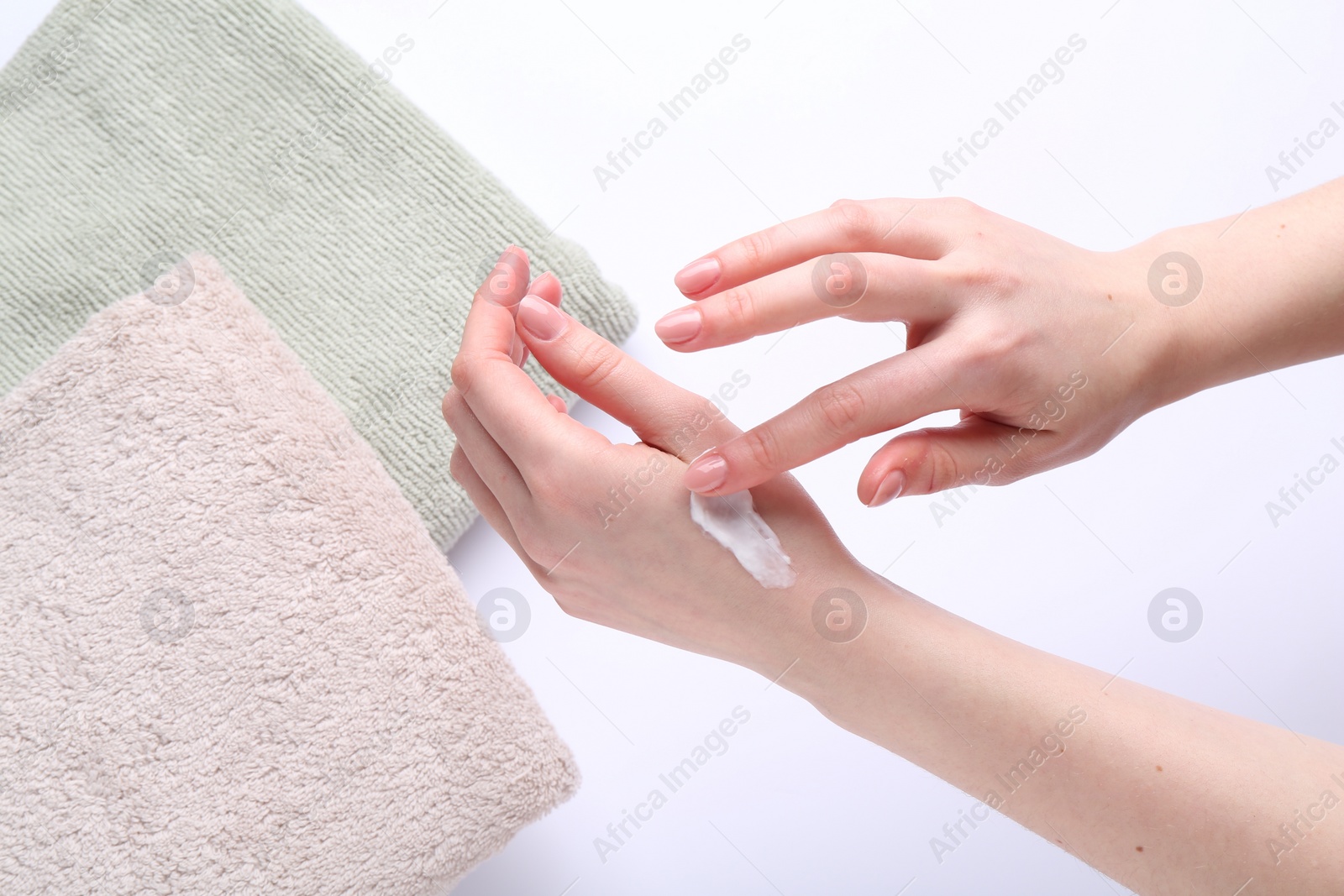 Photo of Woman applying hand cream on white background, above view