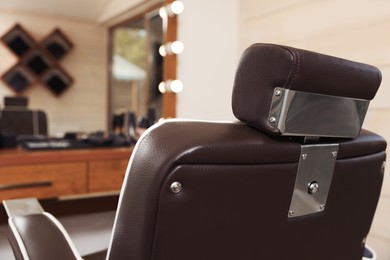 Stylish hairdresser's workplace with professional armchair in barbershop, closeup