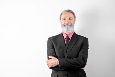 Photo of Handsome bearded mature man in suit on white background