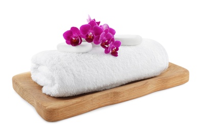 Board with orchid, spa stones and towel on white background