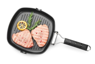 Photo of Grill pan with delicious tuna steaks, lemon and rosemary on white background, top view