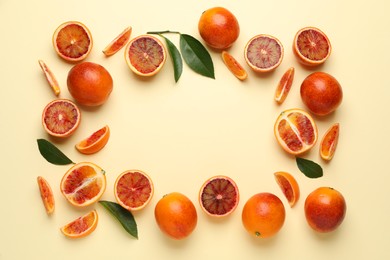 Photo of Frame of ripe sicilian oranges and leaves on beige background, flat lay. Space for text