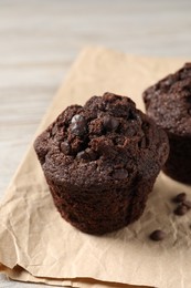 Photo of Delicious chocolate muffins on light wooden table