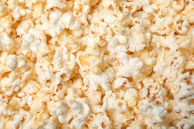 Photo of Fresh tasty popcorn as background, top view