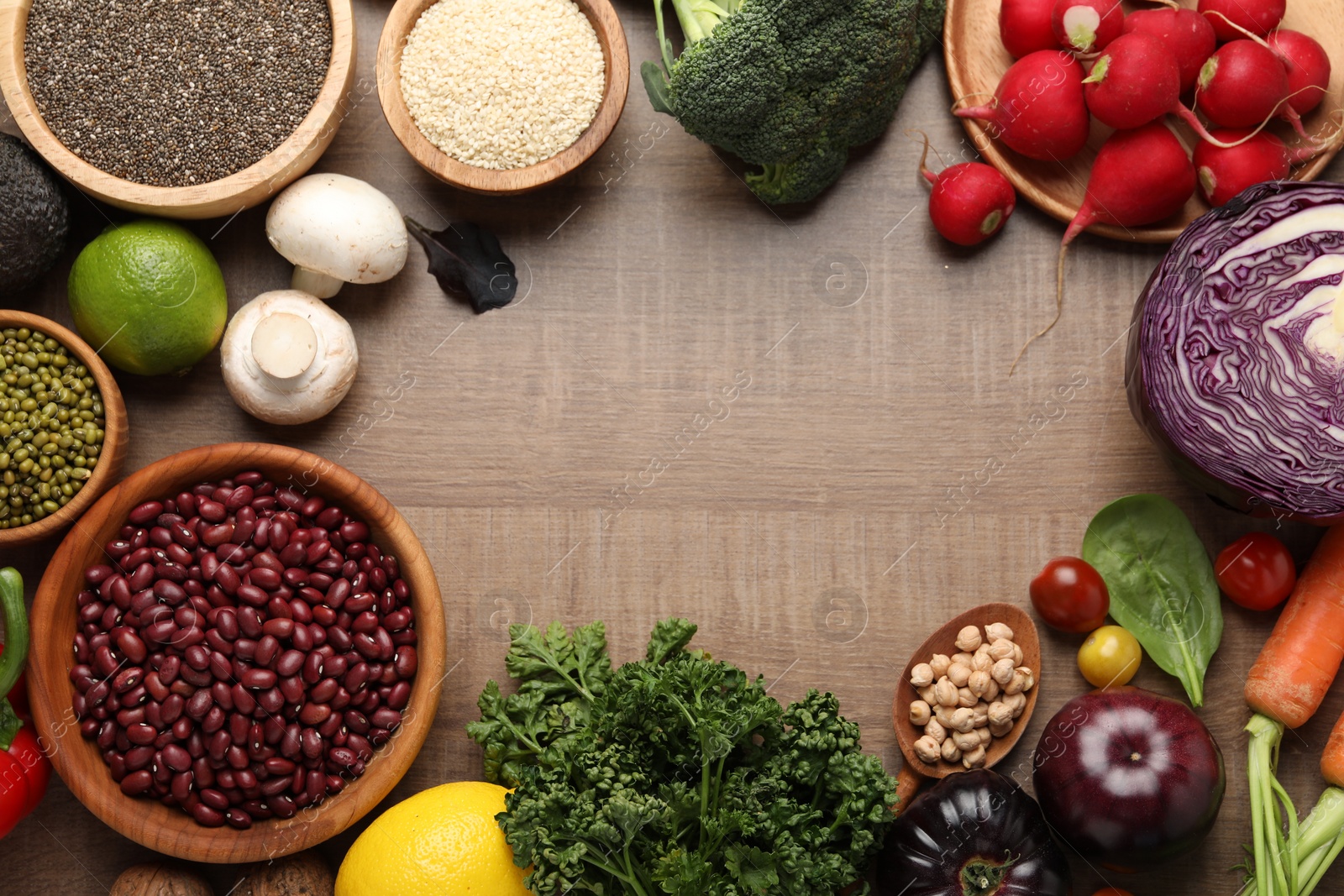 Photo of Frame made of different vegetables on wooden table, flat lay. Vegan diet