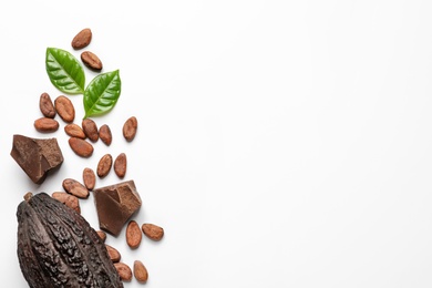 Photo of Cocoa pod with beans and chocolate pieces on white background, top view