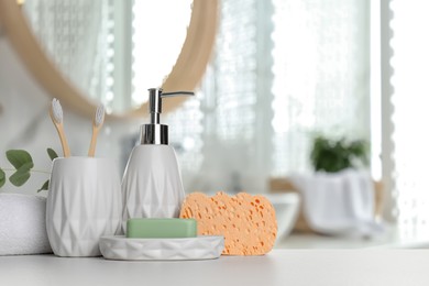 Image of Bath accessories. Different personal care products and eucalyptus leaves on white table in bathroom, space for text