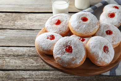 Photo of Pastry stand with delicious jelly donuts on wooden table. Space for text