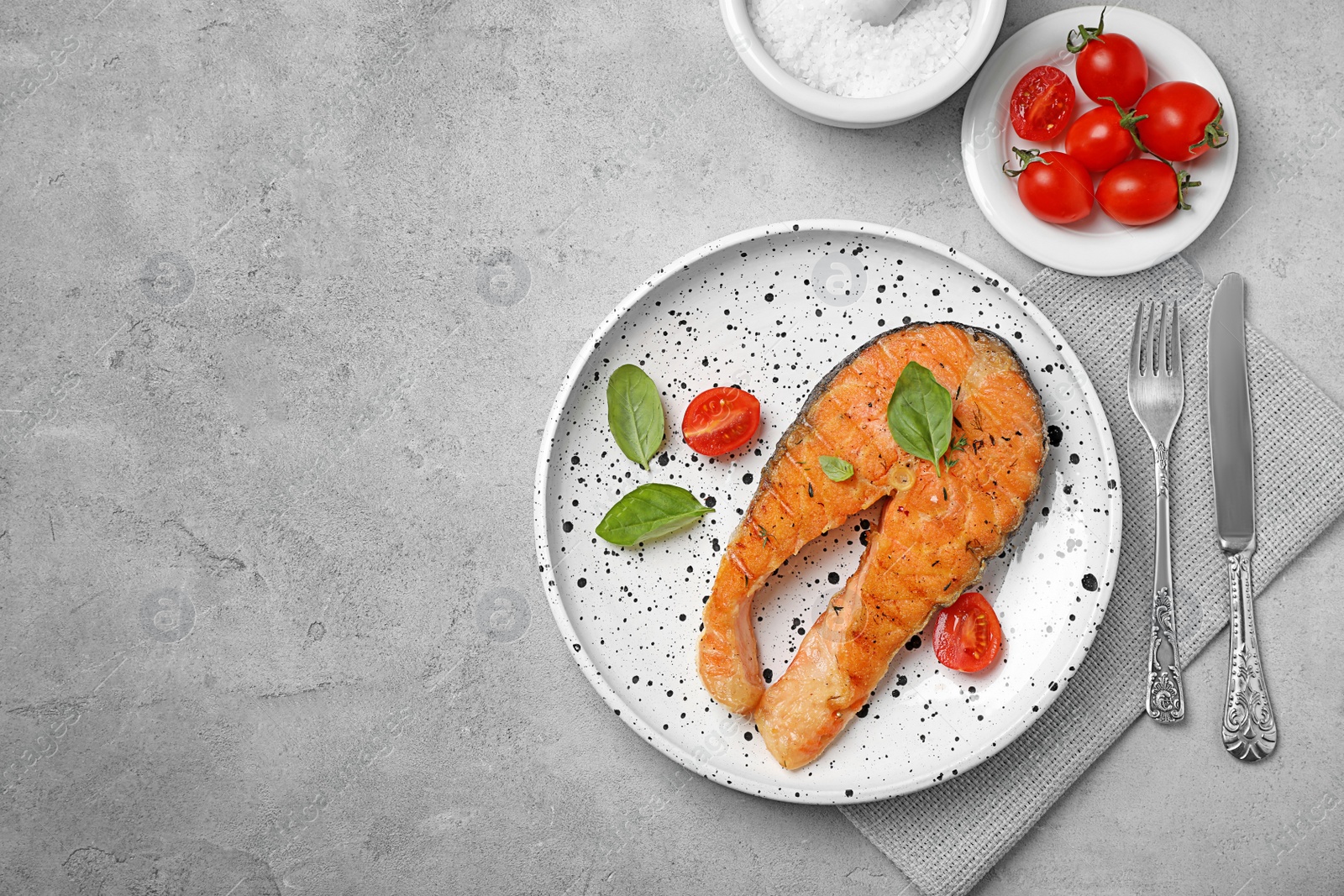 Photo of Plate with tasty salmon steak on grey background