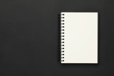 Blank notebook on black background, top view. Space for text