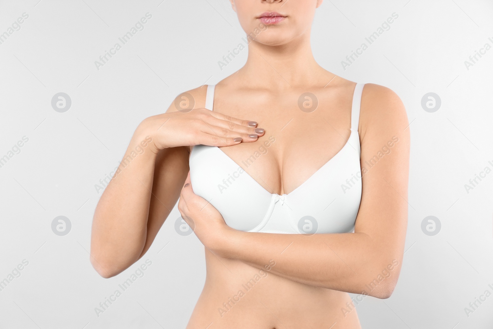 Photo of Woman checking her breast on white background, closeup