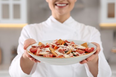 Closeup of professional chef presenting delicious dish in kitchen, focus on food