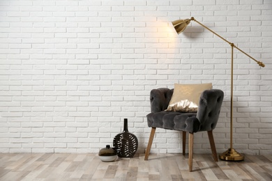 Photo of Stylish living room interior with comfortable armchair near brick wall. Space for text