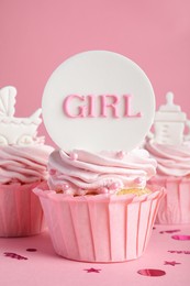 Photo of Beautifully decorated baby shower cupcakes for girl with cream and toppers on pink background