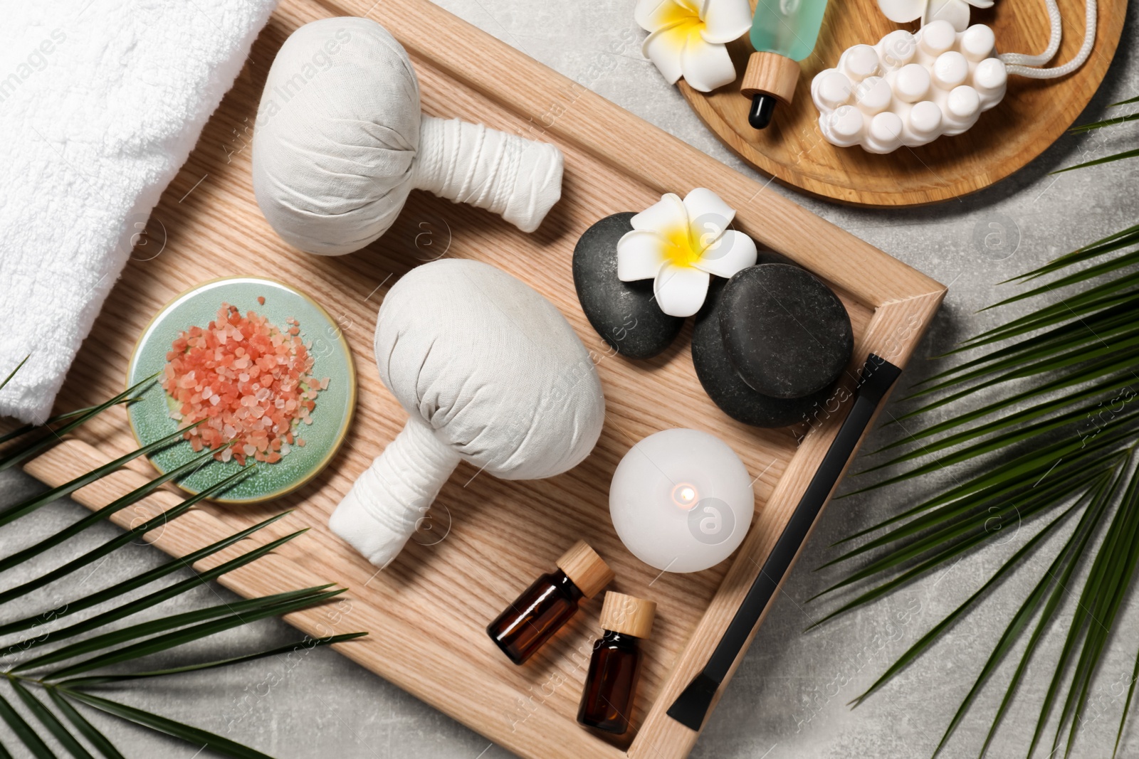 Photo of Flat lay composition with herbal massage bags and other spa products on grey table