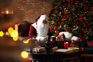 Photo of Santa Claus making new toy for Christmas in workshop