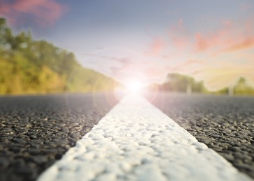 Empty asphalt road at sunrise, closeup view