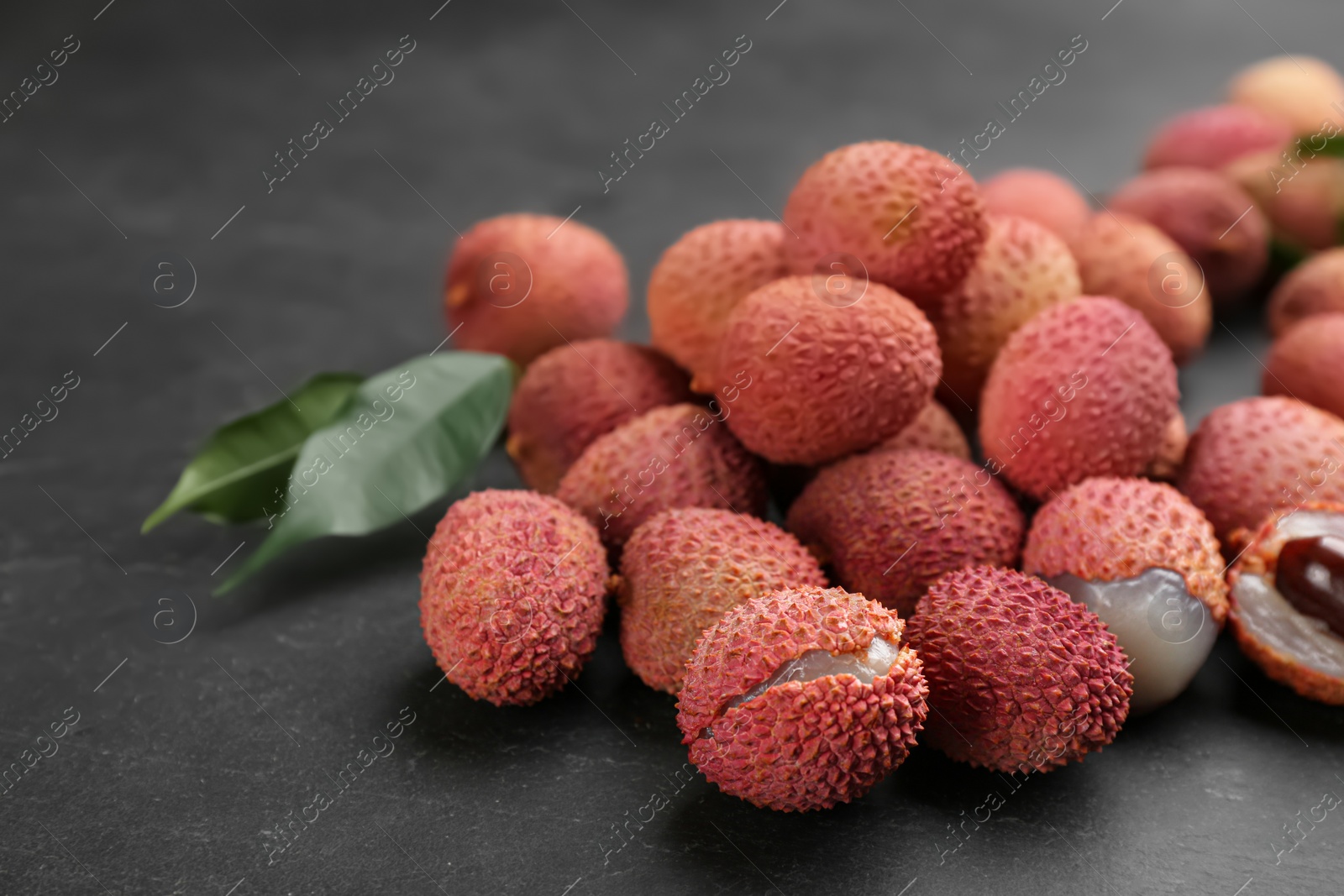 Photo of Fresh ripe lychee fruits on black table