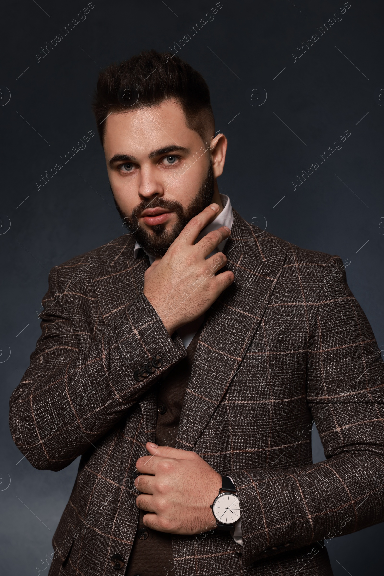 Photo of Handsome bearded man in stylish suit on dark background