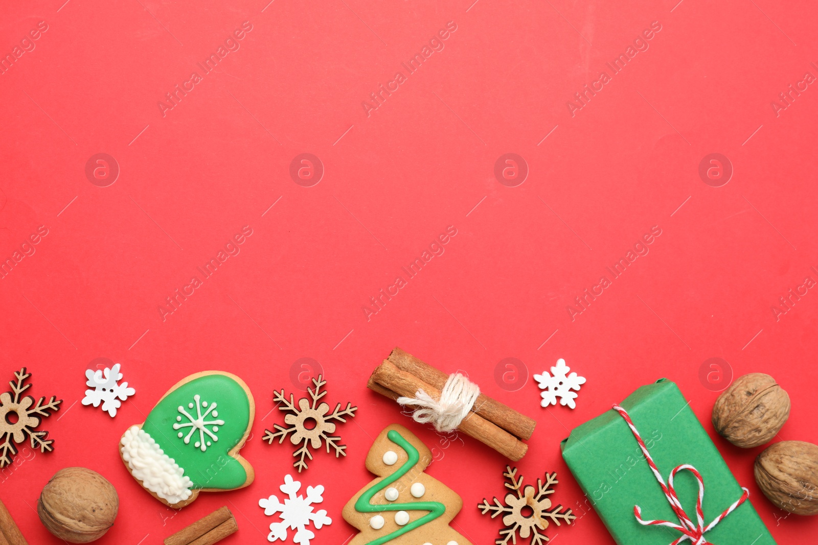 Photo of Flat lay composition with Christmas decorations and treats on red background, space for text. Winter holidays