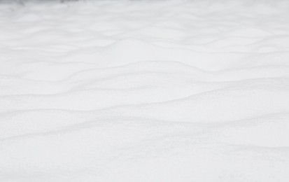 Photo of Beautiful white snow outdoors, closeup. Winter season