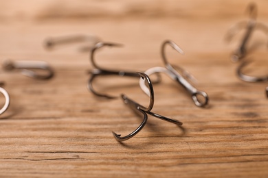 Fishing hooks on wooden table. Angling equipment