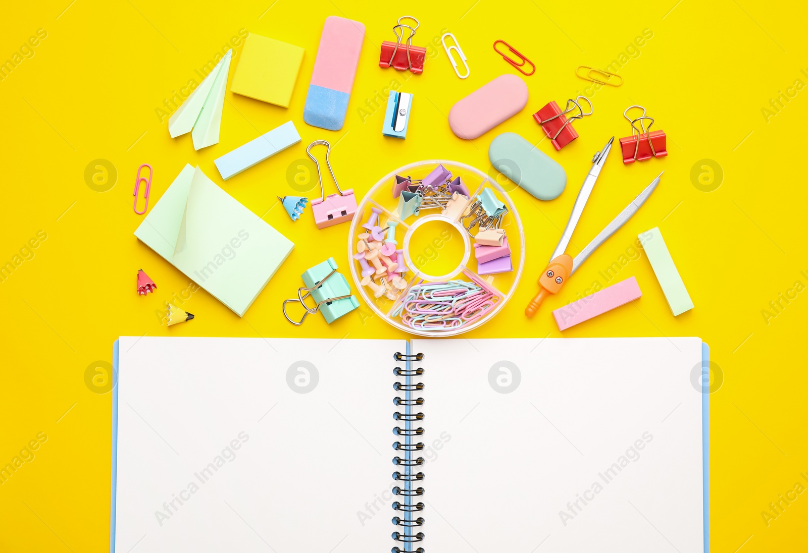 Photo of Flat lay composition with notebook and different school stationery on yellow background. Back to school