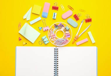 Flat lay composition with notebook and different school stationery on yellow background. Back to school