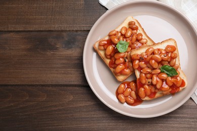 Photo of Toasts with delicious canned beans on wooden table, flat lay. Space for text