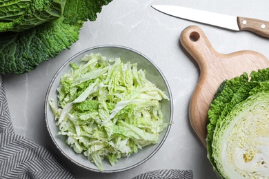 Cut fresh savoy cabbage on light marble table, flat lay
