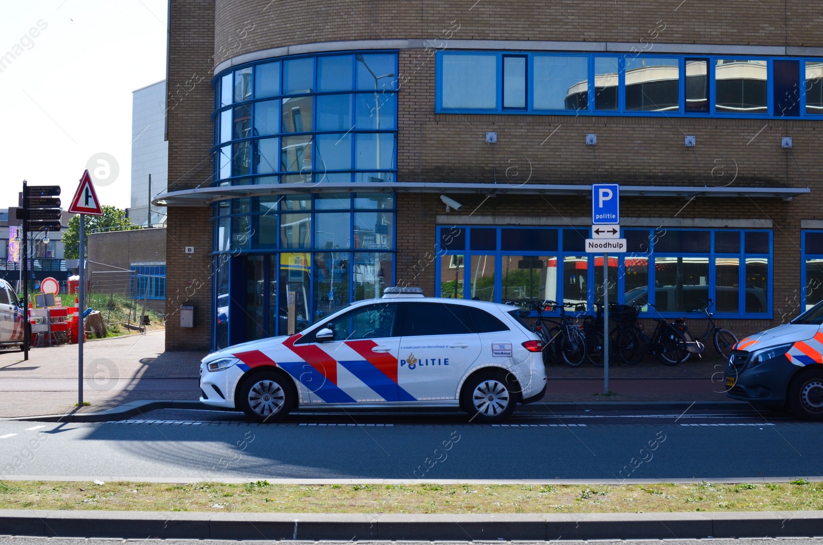 Photo of Hague, Netherlands - May 2, 2022: Police car near modern building in city