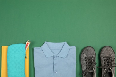 School uniform for girl and stationery on color background, top view