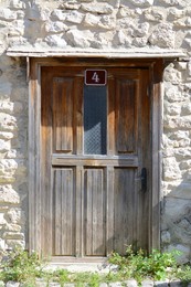 Photo of Entrance of building with old wooden door in stone wall outdoors