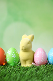 Easter bunny and painted eggs on green grass