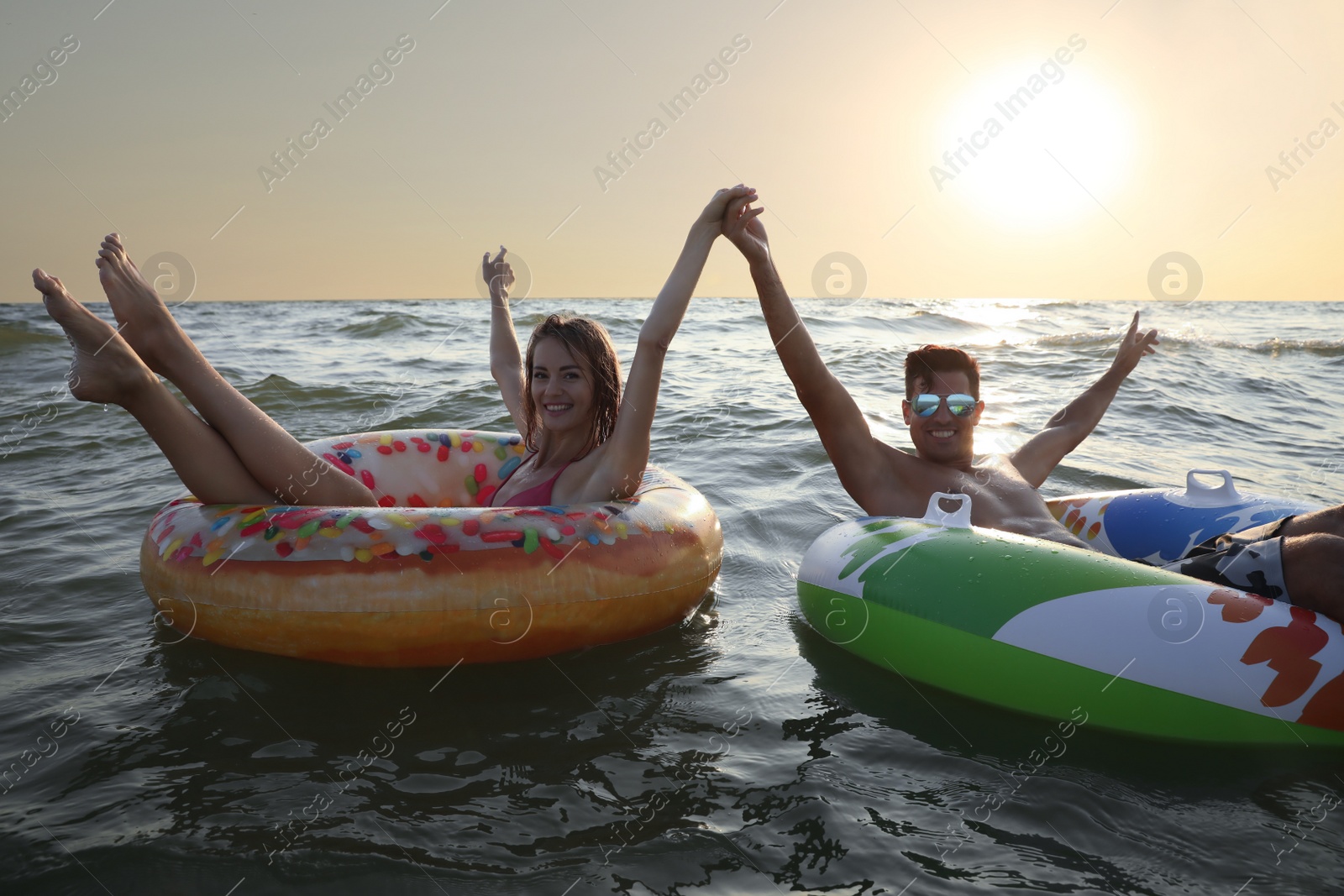 Photo of Happy couple with inflatable rings in sea