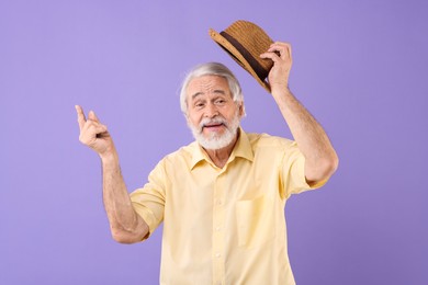 Photo of Portrait of stylish grandpa with hat on purple background