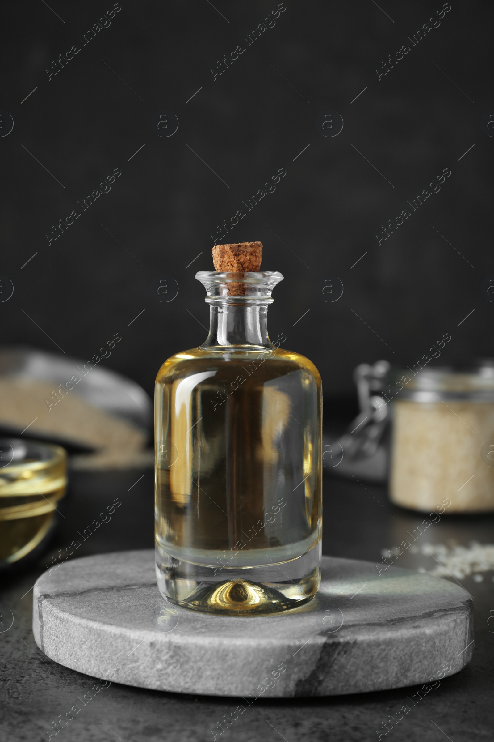 Photo of Sesame oil in glass bottle on dark grey table