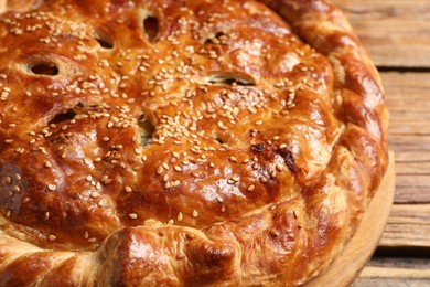 Photo of Tasty homemade pie with filling on wooden table, closeup