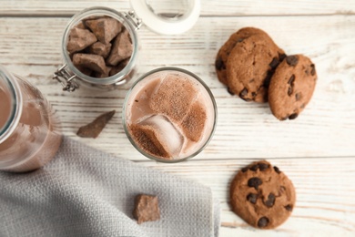 Flat lay composition with glass of tasty chocolate milk on wooden background. Dairy drink