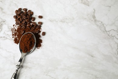 Ground coffee and roasted beans on white marble table, top view. Space for text
