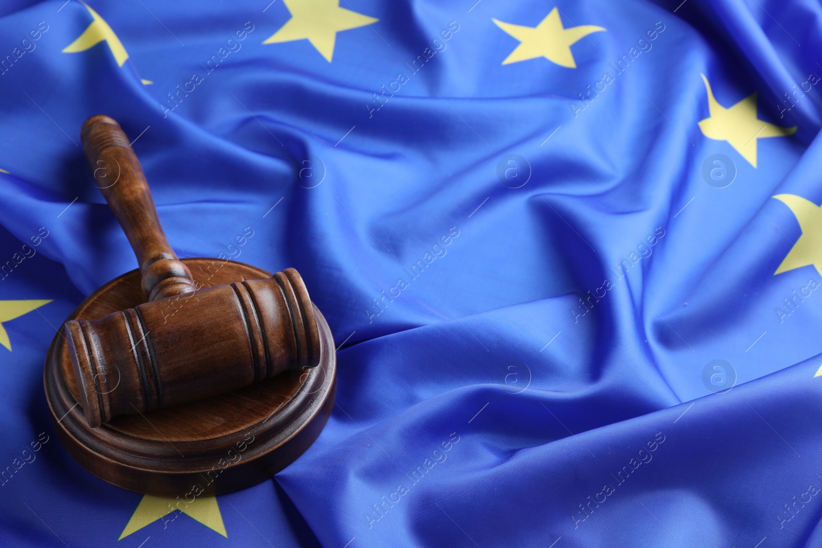 Photo of Wooden judge's gavel on flag of European Union, space for text