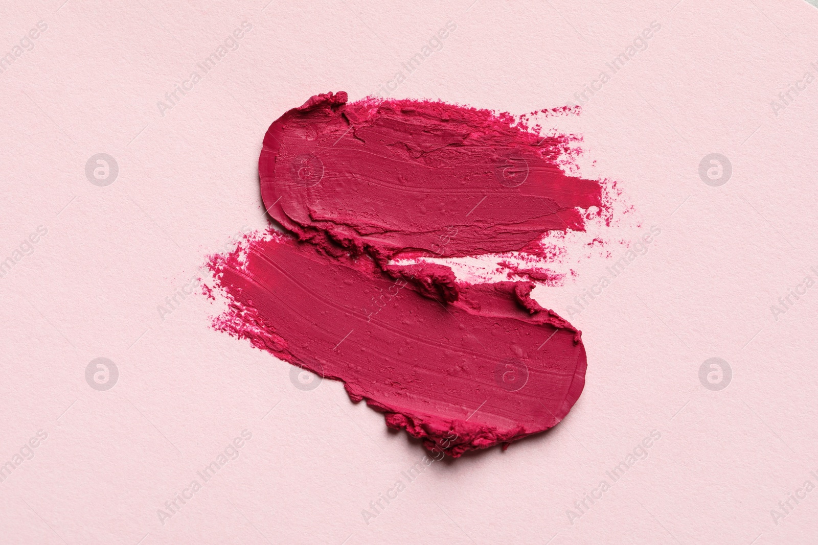 Photo of Smears of bright lipstick on light background, top view