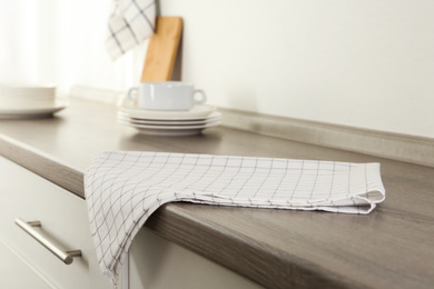 Photo of Checkered cotton towel on wooden table in kitchen